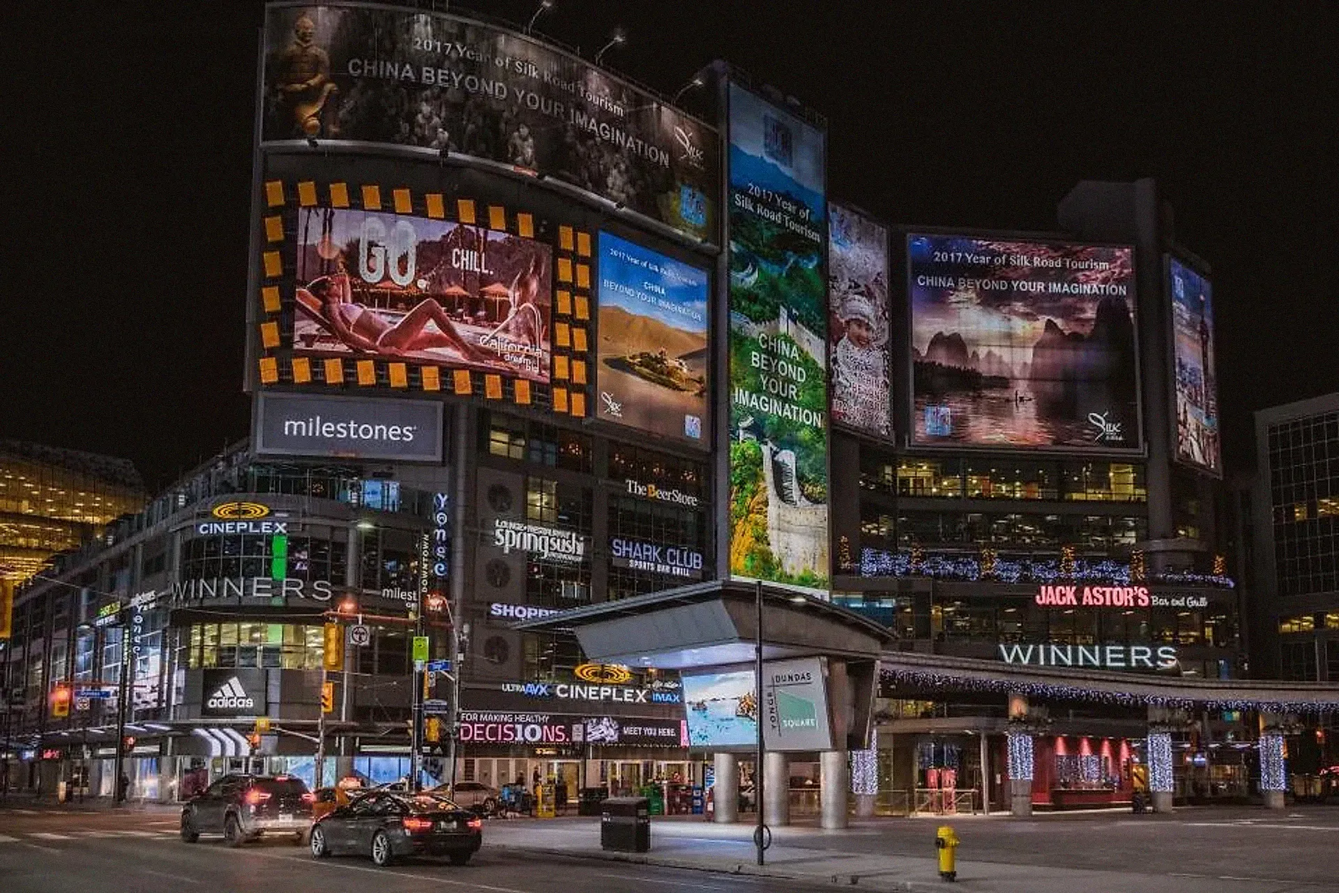 Illuminated advertising billboards on city buildings at night