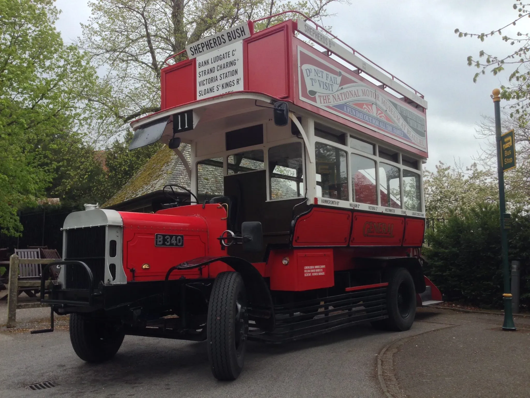 A vintage red London double-decker bus parked on a green