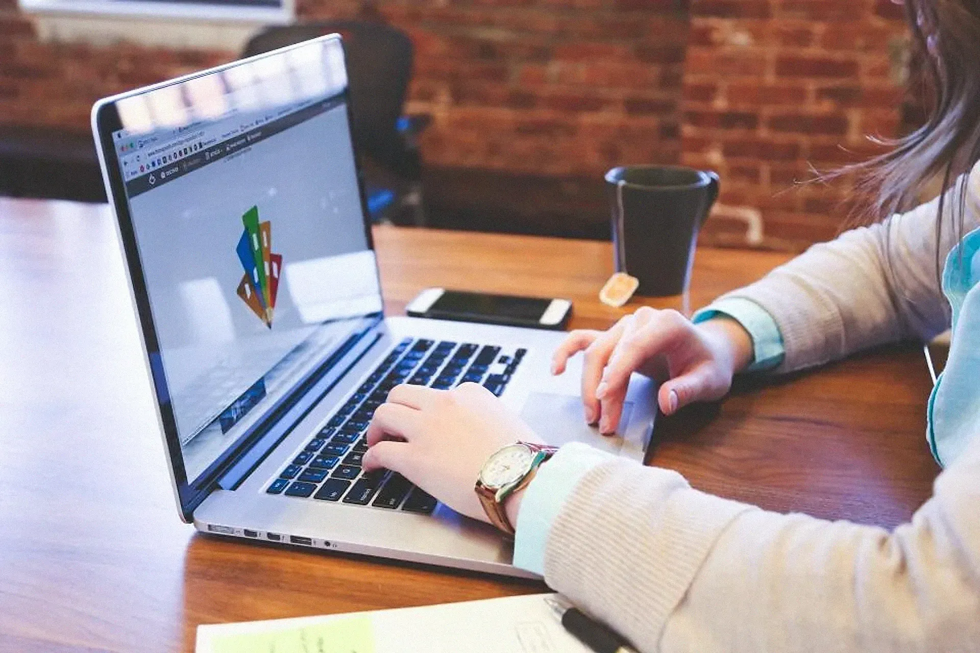 Hands on a laptop keyboard with a website design on screen