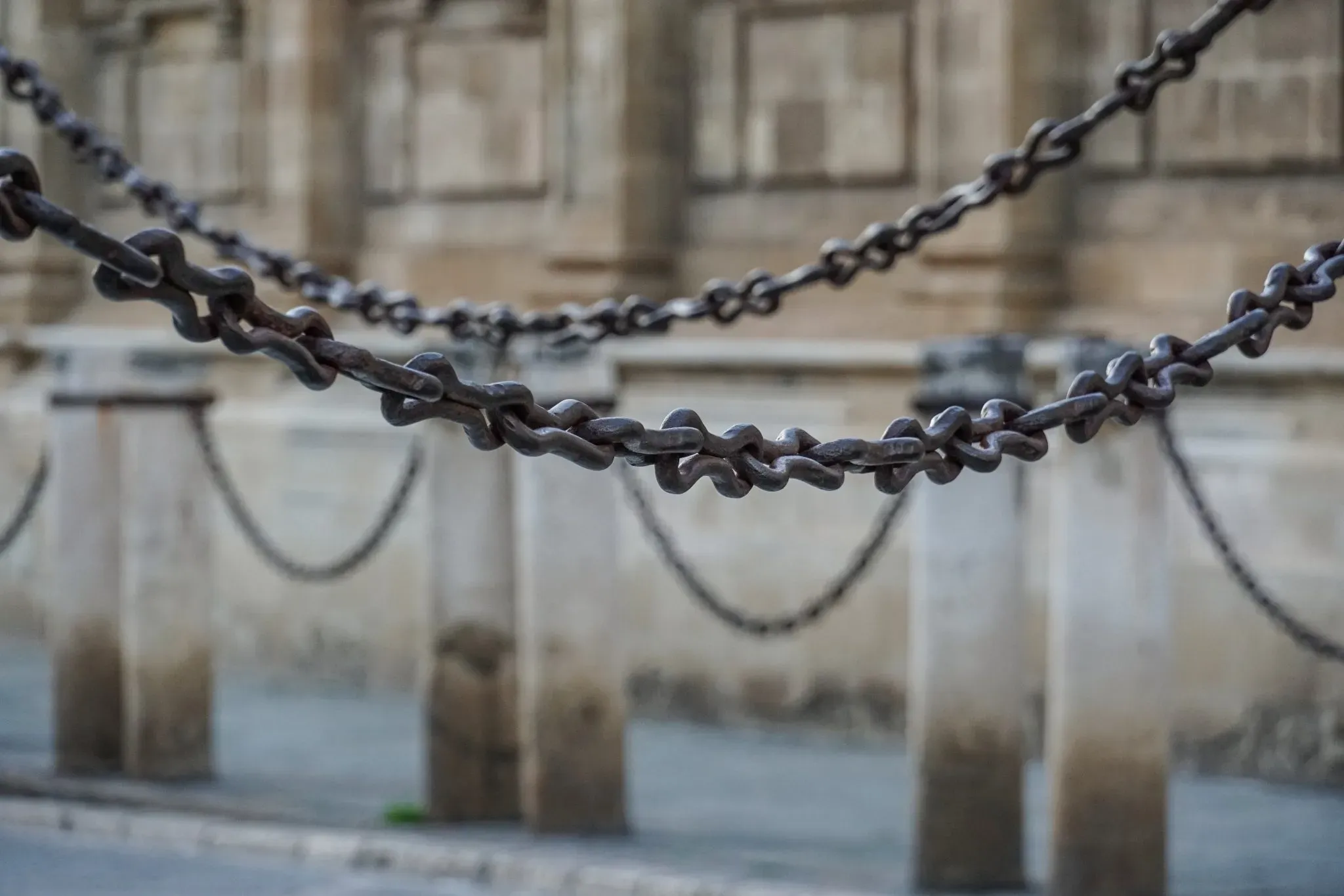 A heavy chain hanging between stone posts
