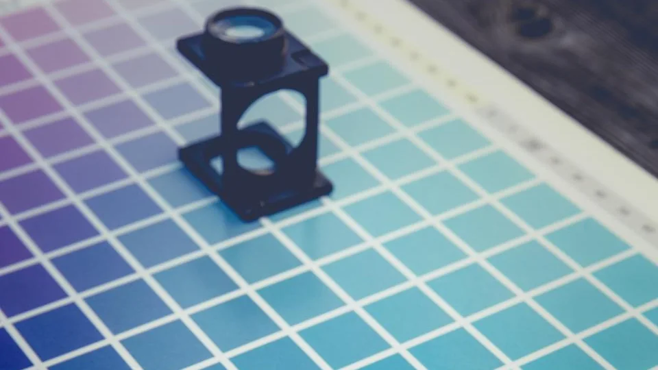 A printed colour chart with a small loupe resting on it
